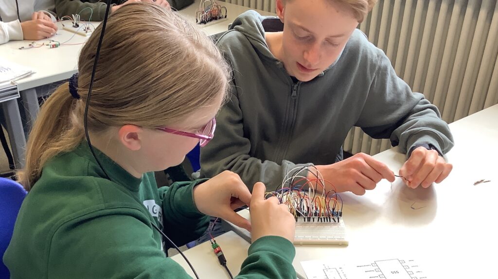 Hectorianer:innen bauen einen BCD-7-Segemnt-Decoder auf einem Steckbrett auf.